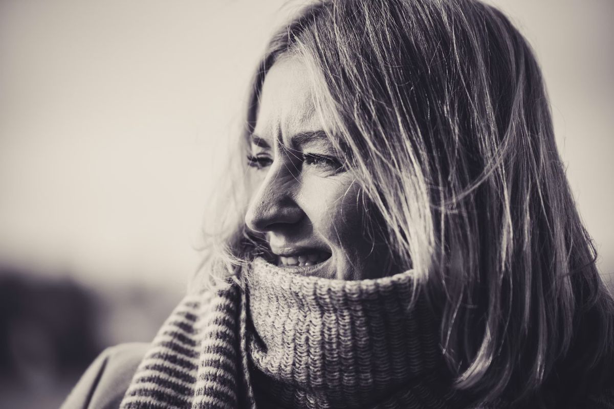 Portrait femme blonde souriante en écharpe.