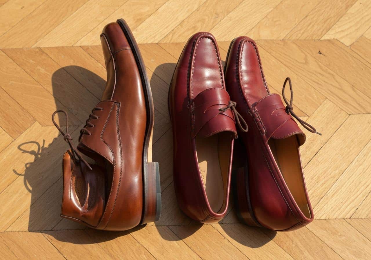 Chaussures marron cognac et bordeaux posées sur parquet