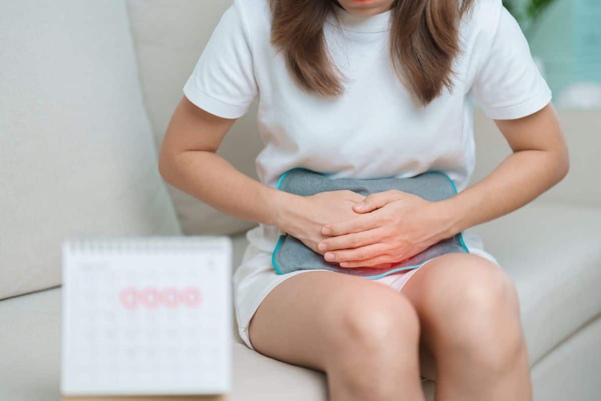 Femme avec bouillotte et calendrier pour règles