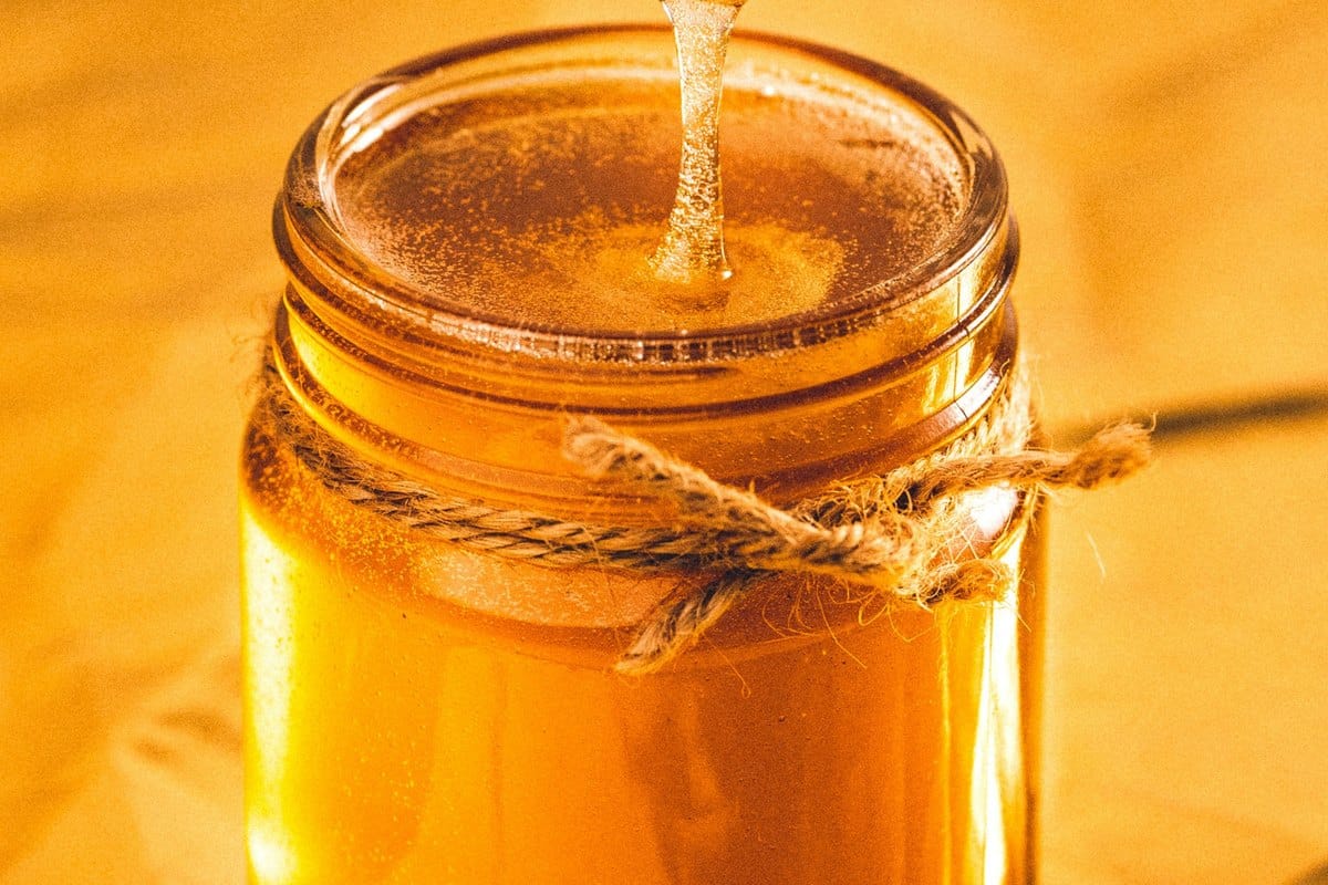 Miel doré coulant dans un bocal