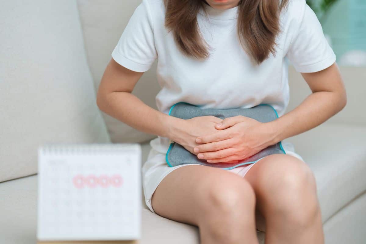 Femme avec bouillotte et calendrier pour règles