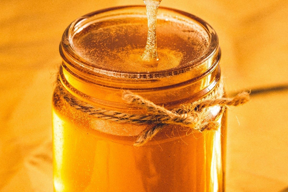 Miel doré coulant dans un bocal